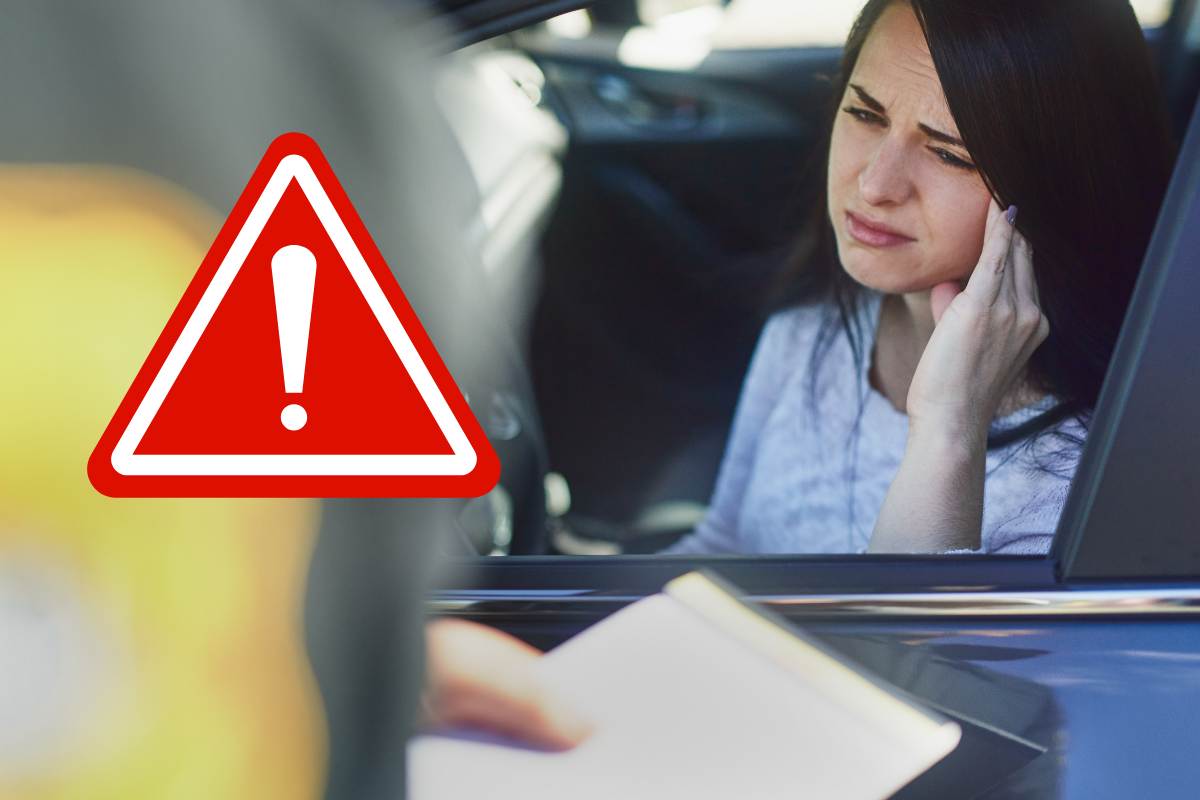 donna in auto multa simbolo pericolo